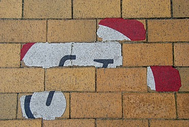 Remains of a "No bicycling" sign on the sidewalk