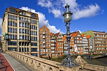 Bridge with ornate lamps leading to Haus der Seefahrt (House of Seafaring) at left beside historic timber-framed merchant houses on the Nikolaifleet in the historic centre of Hamburg, Germany