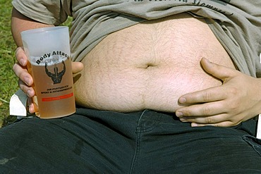 Young man present his beer belly