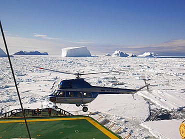 Helicopter landing on Capt. Khlebnikov (icebreaker) after a flight over the icebergs off of Franklin Island, Antarctica