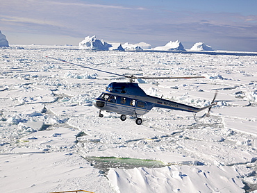 Helicopter landing on the Capt. Khlebnikov icebreaker after a flight over the icebergs off the coast of Franklin Island, Antarctica