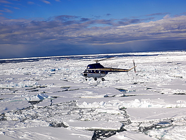 Helicopter flying above sea ice, Antarctica