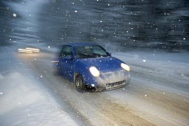 Car at snow flurry road traffic in winter Bavaria Germany