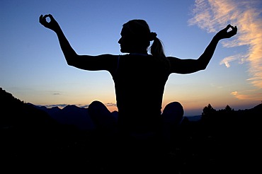 Woman doing yoga in the evening, silhouette