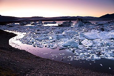 Blue and black icebergs and ice crystals in the evening light, Joekulsarlon glacial lagoon, Vatnajoekull glacier, Austurland, eastern Iceland, Iceland, Europe