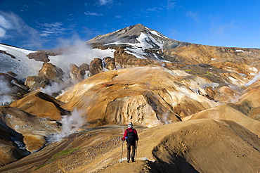 Hiker on a trail, hot springs and snow-capped Rhyolite Mountains, Hveradallir high temperature region, Kerlingarfjoell, highlands, Iceland, Europe