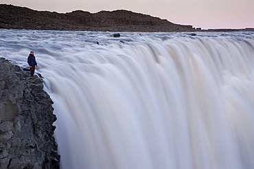 Man standing at the Dettifoss waterfall on the JoekulsâˆšÂ° âˆšÂ° Fjoellum river, Norâˆšâˆžurland eystra region, or north-east region, Iceland, Europe