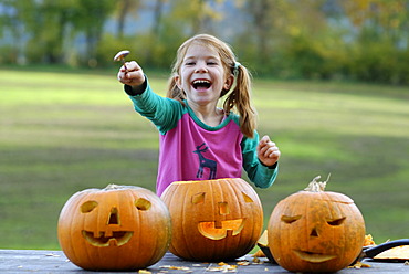 Girl carving a jack-o-lantern from a pumpkin for Halloween