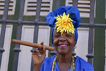 Woman wearing traditional clothes holding a cigar, Havana, Cuba