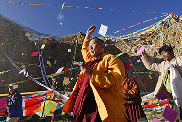 Tibetan pilgrims throwing prayer notes into the air, ceremony at Namtso Lake, Heavenly Lake, Tibetan, China, Asia