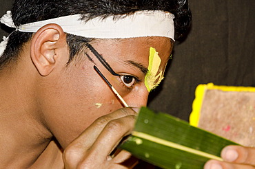 The make-up of the Kathakali character Krishna is being applied, Perattil, Kerala, India, Asia