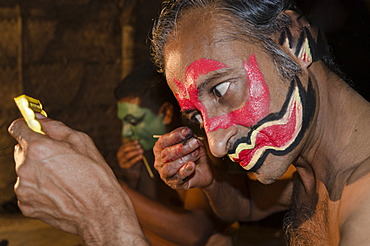 The make-up of a Kathakali dancer is being applied, Perattil, Kerala, India, Asia