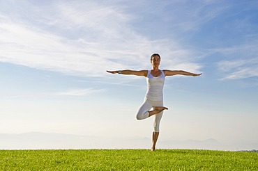 Young woman practising Hatha yoga outdoors, showing the pose vrikshasana, tree, Nove Mesto, Okres Teplice, Czech Republic, Europe