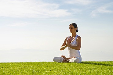 Young woman practising Hatha yoga outdoors, showing the pose padmasana, lotus pose, Nove Mesto, Okres Teplice, Czech Republic, Europe