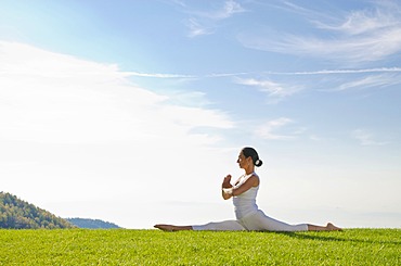 Young woman practising Hatha yoga outdoors, showing the pose anjaneyasana, hanumanasana, split, Nove Mesto, Okres Teplice, Czech Republic, Europe