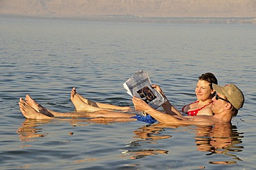 Tourists reading the newspaper in the Dead Sea near Suwaymah, Jordan, Middle East, Orient