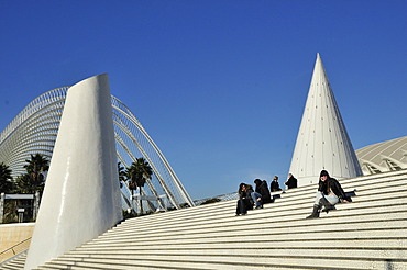 Tourists sitting on the steps of the Ciudad de las Artes y las Ciencias, City of Arts and Sciences, designed by Spanish architect Santiago Calatrava, Valencia, Comunidad Valenciana, Spain, Europe