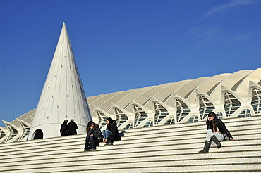 Tourists sitting on the steps of the Ciudad de las Artes y las Ciencias, City of Arts and Sciences, designed by Spanish architect Santiago Calatrava, Valencia, Comunidad Valenciana, Spain, Europe