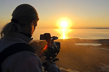 Camerawoman filming sunset, USA, United States of America