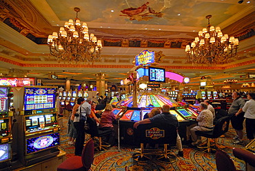 Gamblers sitting in front of slot machines at The Venetian Resort Hotel & Casino on the Strip, Las Vegas Boulevard, Las Vegas, Nevada, USA, North America