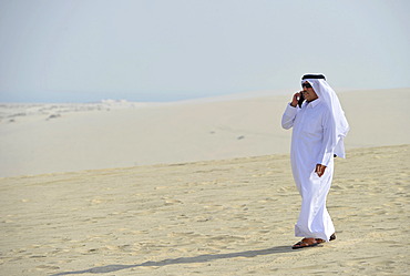 Qatari on a cell phone, in traditional clothing with gutra, Emirate of Qatar, Persian Gulf, Middle East, Asia