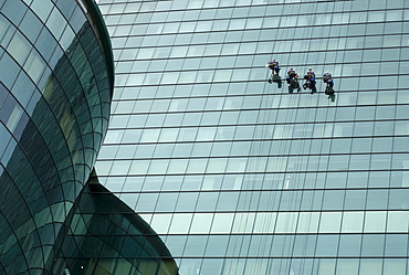 Window cleaners on a modern glass facade in Saigon, Ho Chi Minh City, Vietnam, Southeast Asia