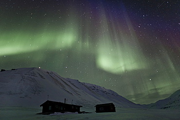 Green Northern Lights, Aurora Borealis, above two small huts in a starry sky, Adventdalen, Todalen, Longyearbyen, Spitsbergen, Svalbard, Norway, Europe