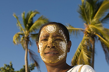 Portrait of smiling, dark-skinned woman with facial painting, Nosy Be, Madagascar, Africa