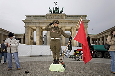 A man dressed up as a soviet army soldier poses in front of the Brandenburger Tor, Berlin