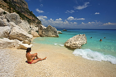 Woman lying on the beach, Cala Goloritze bay, Golfo di Orosei, Gennargentu National Park, Sardinia, Italy, Europe