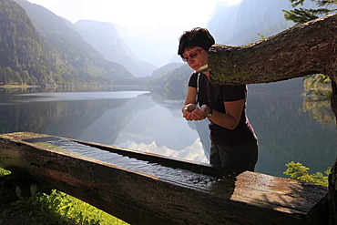 Hiker refreshing herself at a trough, Gosausee lake, Gosau, Salzkammergut region, Upper Austria, Austria, Europe