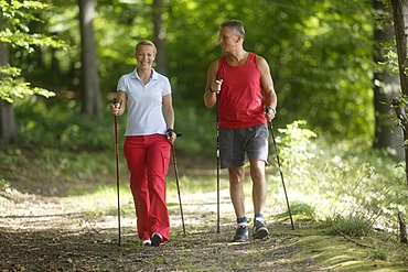 Woman, 42, and man, 52, doing Nordic Walking