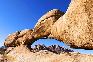 Rock arch, Pontok Mountains at the back, near the Spitzkoppe granite peaks, Damaraland, Namibia, Africa