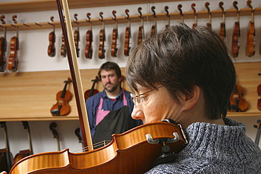 Violin-maker (luthier) with a customer in his shop