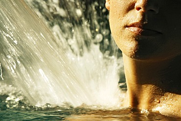 Woman getting her shoulders massaged by warm water