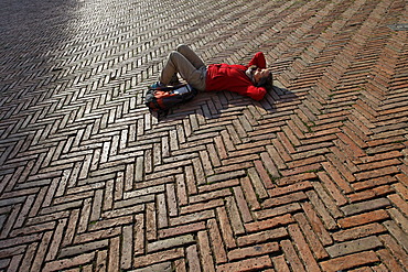 Tourist lying in the Piazza del Campo square, Siena, Tuscany region, province of Siena, Italy, Europe