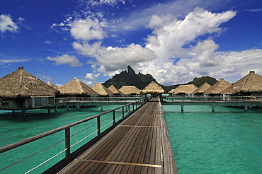 Boardwalk, huts on stilts, Mt Otemanu at back, from St. Regis Bora Bora Resort, Bora Bora, Leeward Islands, Society Islands, French Polynesia, Pacific Ocean