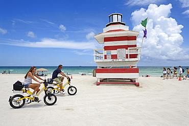 Couple riding electric bicycles, Watchtower, The Jetty, Miami Rescue Tower, South Beach, Miami, USA