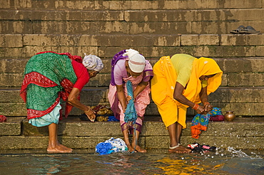 Women washing clothes on the Ghats or holy stairs, Ganges, Varanasi, Uttar Pradesh, India, Asia