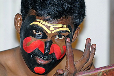 Applying the make-up for the power-hungry Kathakali character Chuvanna Thaadi, Kathakali dance theatre, Kochi, Kerala, South India, India, Asia