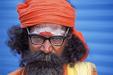 Sadhu wearing glasses in front of a blue wall, portrait, Ramanathaswami Temple, Rameshwaram or Ramesvaram, Tamil Nadu, South India, India, Asia