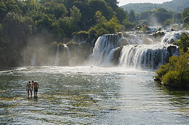 Couple standing in front of waterfalls in Krka National Park, Skradin, Sibenik-Knin, Dalmatia, Croatia, Europe