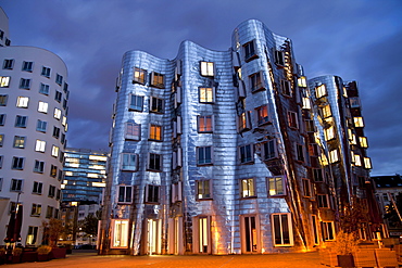 A building by American architect Frank O. Gehry at night, Neuer Zollhof building complex, Medienhafen district, Duesseldorf, North Rhine-Westphalia, Germany, Europe