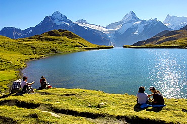 Walkers having a rest next to Bachalpsee lake near Grindelwald First, Swiss Alps, Canton of Bern, Switzerland