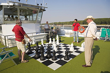 Passengers on a Danube cruise playing chess on deck of the "MS Amadeus Royal" near Galati, Romania, Europe