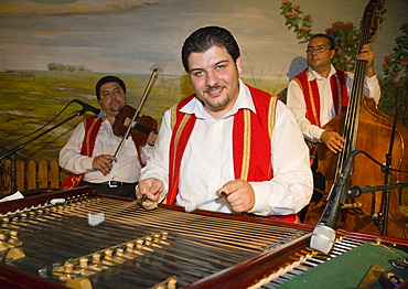 The Roma-band "Lugosi" with a Cimbalom player in the foreground, is playing in a Csarda, a traditional Hungarian tavern, Budapest, Hungary