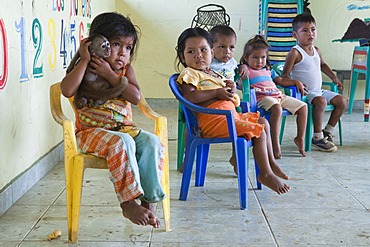 Children in a pre-school, girl holding a tame monkey, primary school in a village without road access in the Oriente rain forest, Curaray, Ecuador, South America