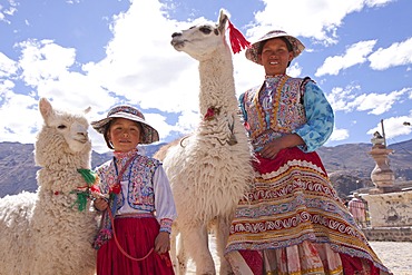 Woman and girl with llama and alpaca in Maca near Colca Canyon, Peru, South America