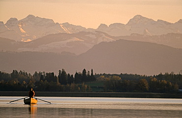 Fisherman on Lake Pfaeffikon in front of the Alps, Switzerland, Europe