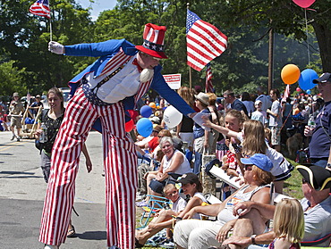 Uncle Sam on stilts greets the crowd at the July 4 parade in a small New England town, Amherst, New Hampshire, USA